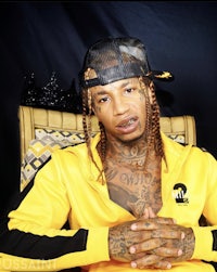 a man with dreadlocks sitting on a chair